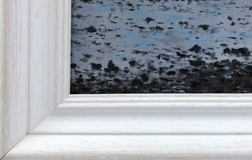 Close up of the white painted wood picture frame.