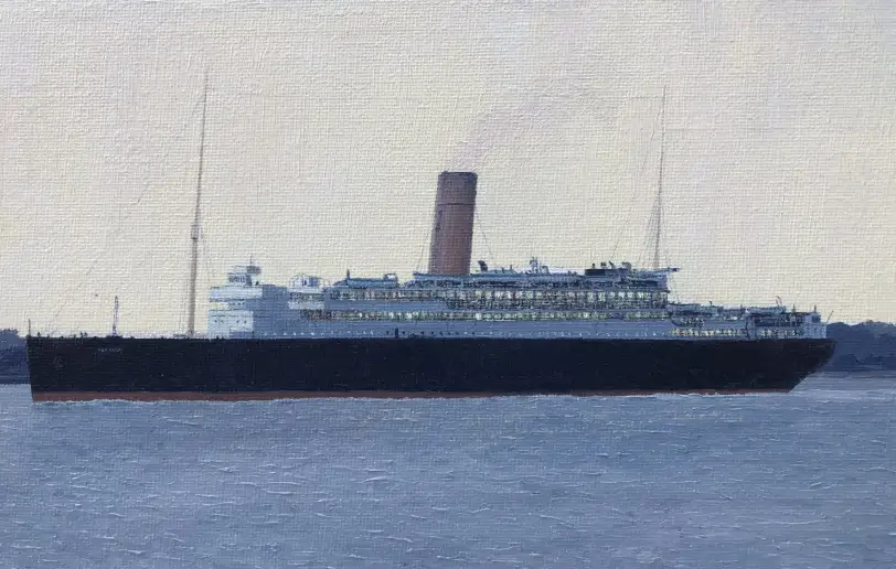 Close up of the ship RMSP Asturias on the water under a dark, cloudy evening sky.