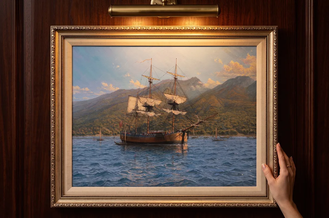 The framed HMB Endeavour oil painting mounted on rich wood wall panelling illuminated under a warm picture light.