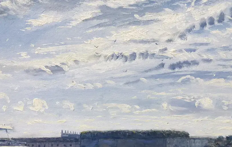 Close up of the cloudy sky and the long stone structure of Fort Adams in the background.