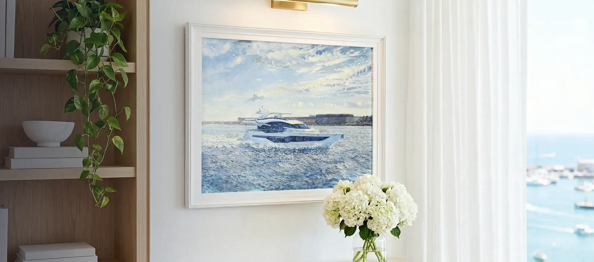 Framed painting of the Galeon 800 Fly hanging on a white wall above a light wood console table decorated with white hydrangeas.