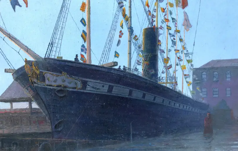 Close up of the ship's bow and the Union Jack flag flying among colorful bunting, with the hazy Bristol cityscape and a glowing sunrise in the background.