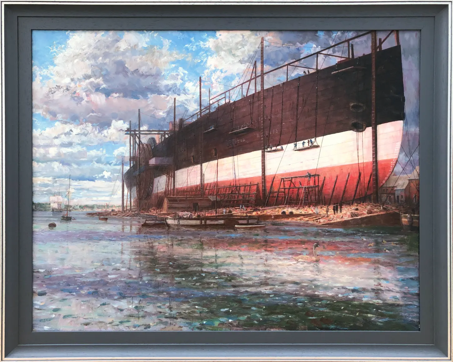 Oil painting in a dark grey frame showing the massive iron hull of Brunel's ship Great Eastern under construction on the banks of the Thames at Millwall. Scaffolding surrounds the colossal vessel, with tiny figures conveying its sheer scale.