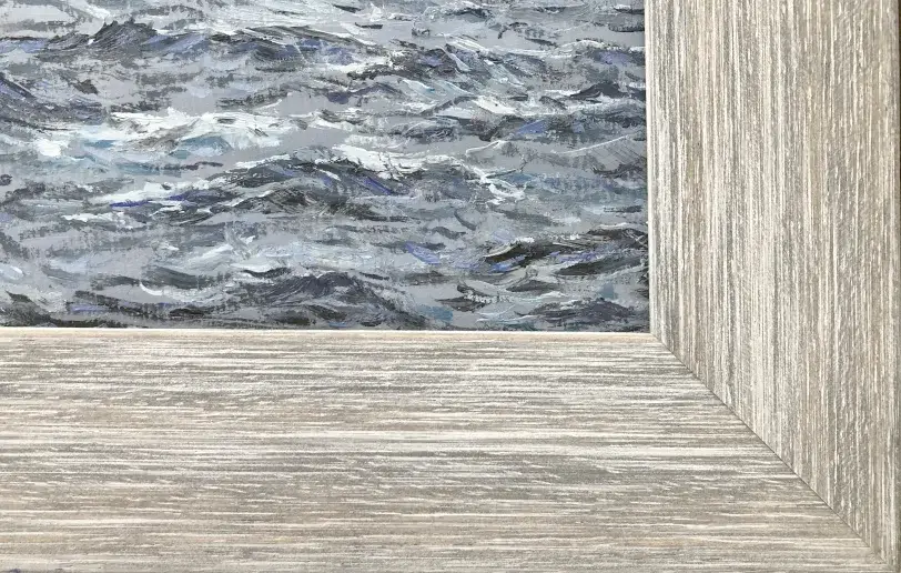 Close up of the distressed light wood picture frame, contrasting with the dark, choppy painted waves.