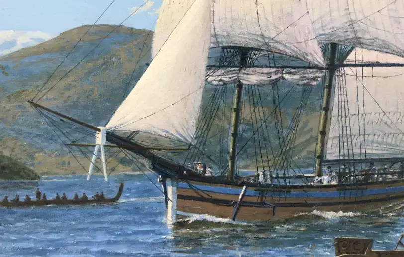 Close up of the bow of the Lady Nelson under sail, with one of the Māori canoes passing in the foreground against the coastal hills.