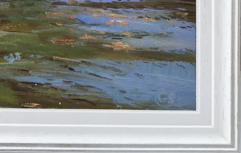 Close up of the white wood picture frame and the expressive brushstrokes of the water.