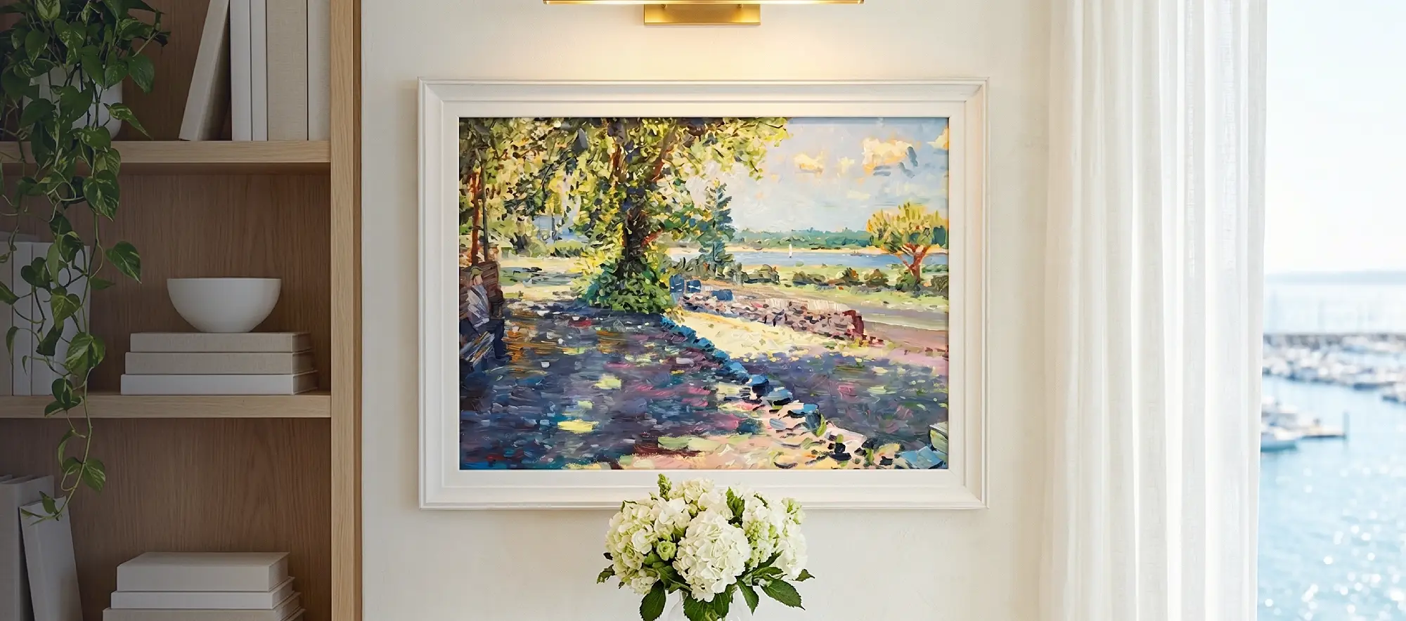 Framed painting of the Mayflower Park view hanging on a white wall above a light wood console table decorated with white hydrangeas.