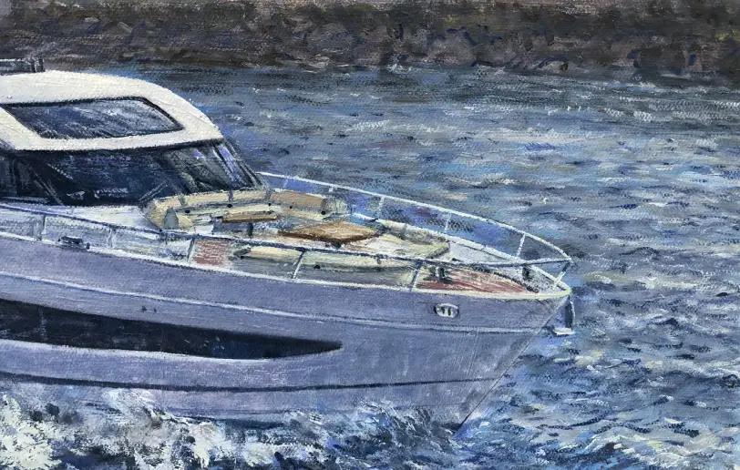 Close up of the bow and forward seating area of the yacht with the Mediterranean coastline in the background.