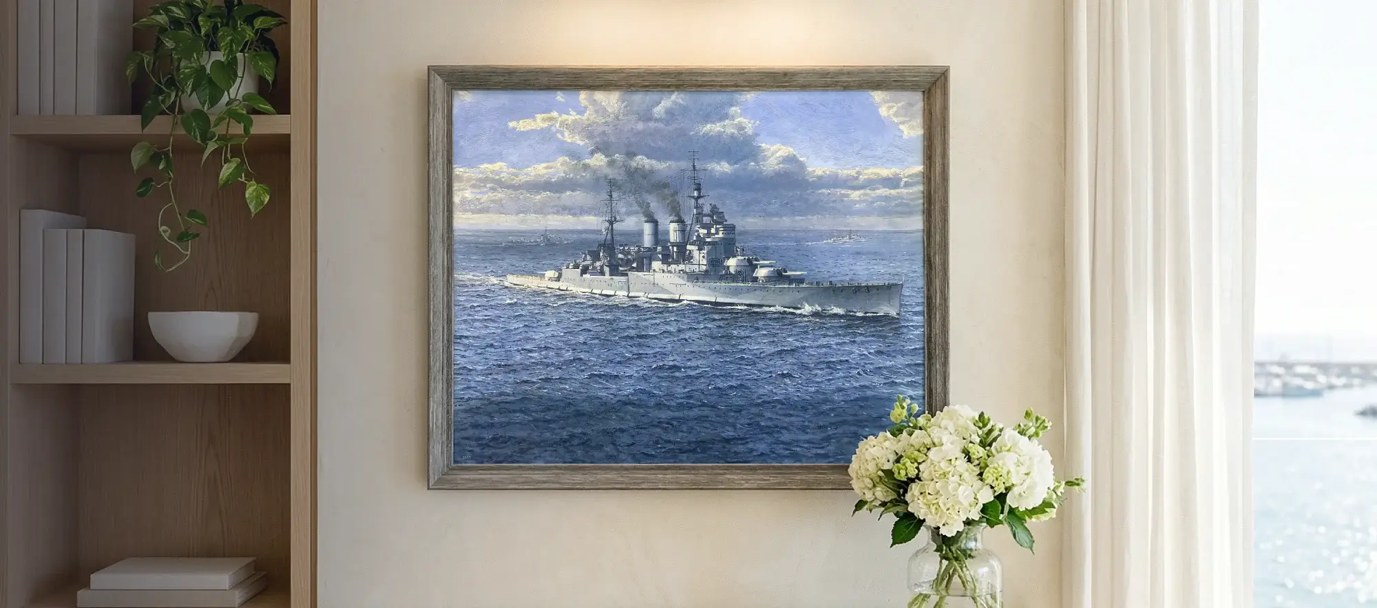 Framed painting of HMS Renown hanging on a white wall above a light wood console table decorated with white hydrangeas.