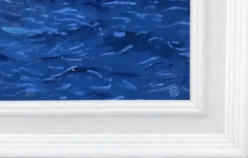Close up of the stepped white wooden frame, showing the dark blue brushstrokes of the painted ocean.