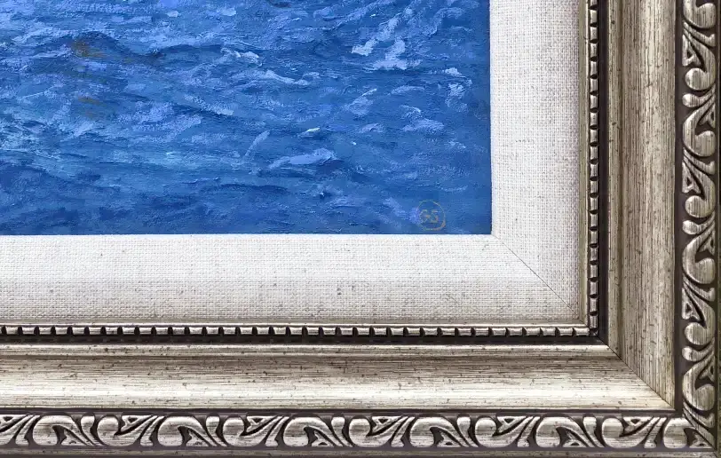 Close up of the ornate picture frame, inner white linen slip, and the textured thick blue oil paint of the ocean waves.