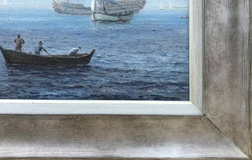 Close up of the silver-grey picture frame and inner white slip over the dark sea painted in the lower right corner.