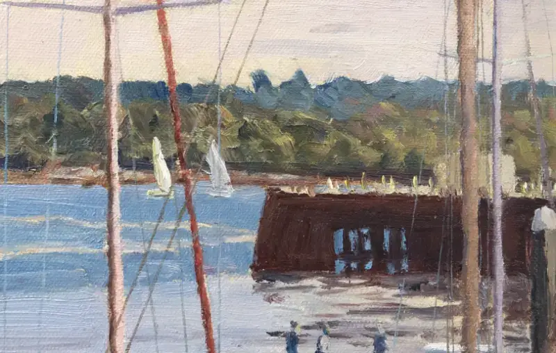 Close up of the marina structure, distant sailing boats on the water, and figures standing on the pier.